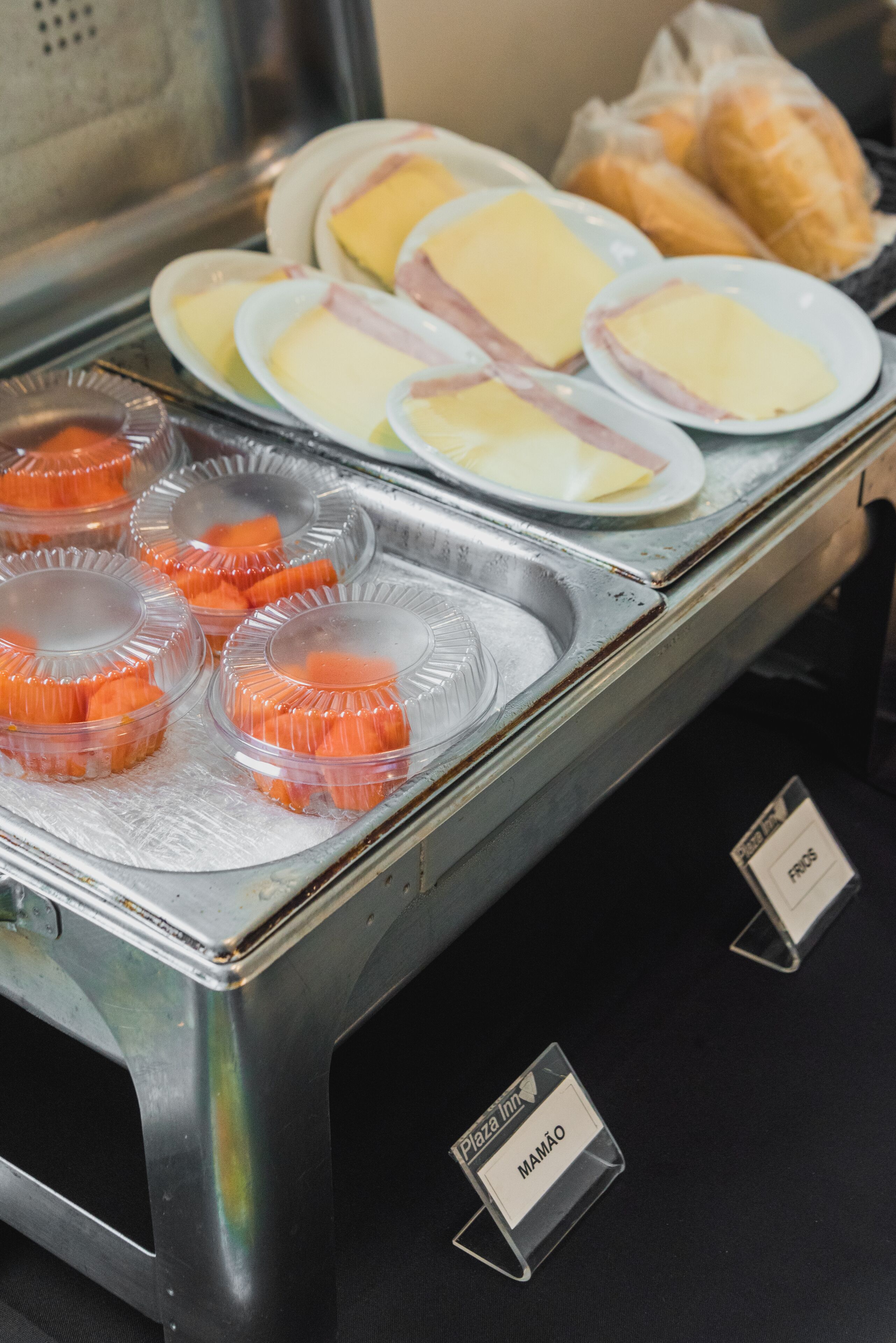 A buffet with various food items including cheese, ham, and orange slices.