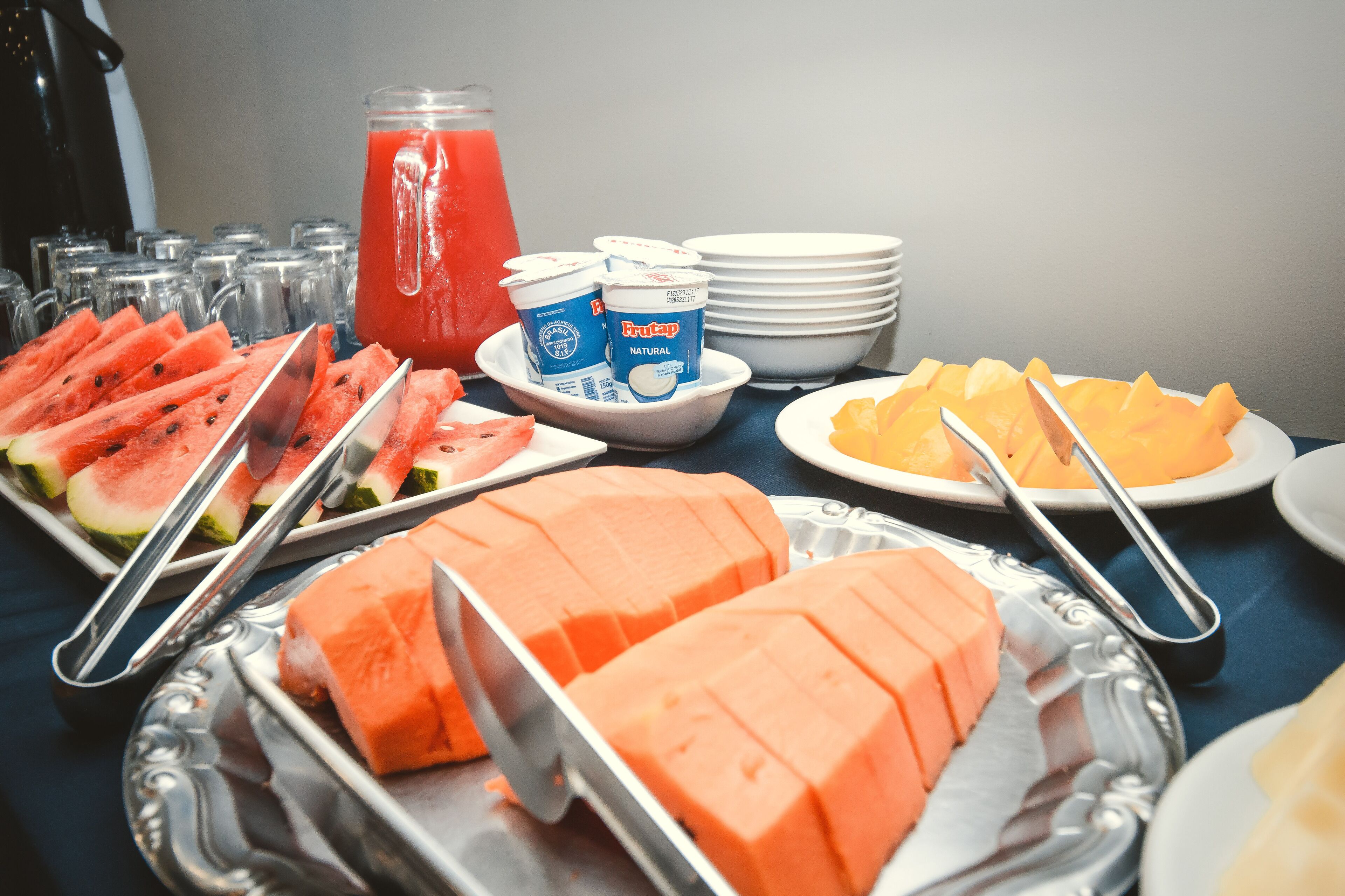 Ett bord med ett urval av olika frukter och drycker, upplagt som en buffé.