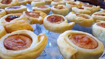 A tray of sausage rolls arranged on a clear glass plate.