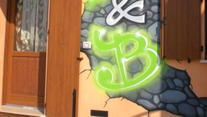 Une façade d’immeuble ornée d’une fresque murale de style graffiti, sur laquelle figurent les lettres « B & B » en vert et en blanc.