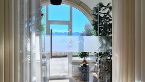 A hallway with a glass door leading to a balcony with a view.