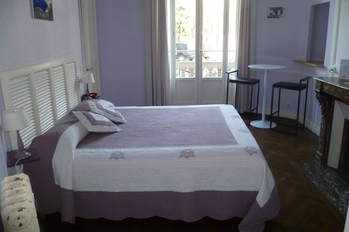 Une chambre à coucher avec un lit, des lampes de chevet, un bureau et une chaise.