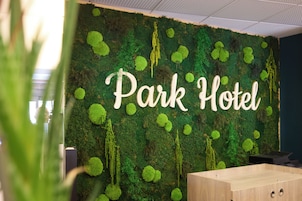 Un mur sur lequel est inscrit le texte « Park Hotel » et un bureau en bois.