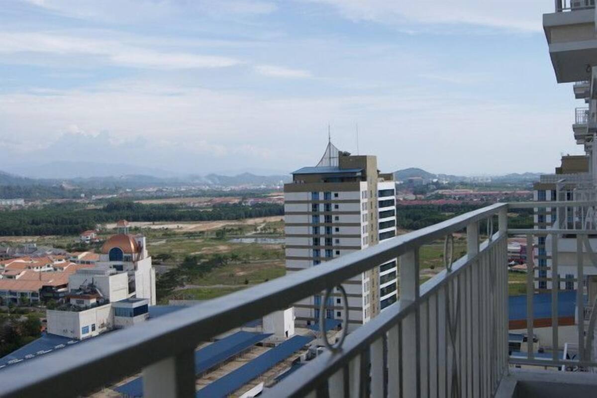 Ein Hochhaus mit mehreren Balkonen, freiem Blick auf die umliegende Landschaft und einem fernen Gebirge.