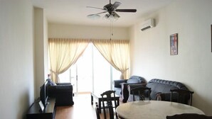 A living room with a dining table, chairs, a sofa, and a ceiling fan.