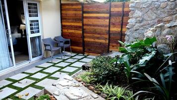 Une terrasse carrelée en pierre, une clôture en bois et un mur en pierre.