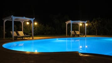 Una piscina al aire libre de temporada, sombrillas