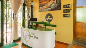 A hotel reception desk with a green and white color scheme, a reception counter, and a wall-mounted sign for 'Ayenda Hoteles'. - Hotel Ayenda Habana Vieja 1221 (Medellín)