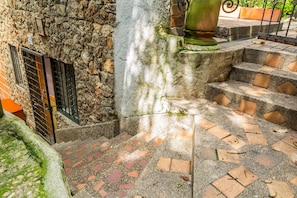 A stone wall with a metal gate and a staircase with brick steps. - Hotel Ayenda Habana Vieja 1221 (Medellín)