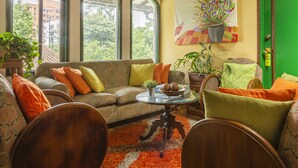 A cozy living room with a sofa, armchairs, a coffee table, and a green door. - Hotel Ayenda Habana Vieja 1221 (Medellín)