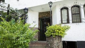A white building with a stone wall, a green gate, and steps leading to the entrance. - Hotel Ayenda Habana Vieja 1221 (Medellín)