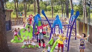 Un parque infantil con diversas estructuras de juego, incluyendo toboganes y juegos de escalar.