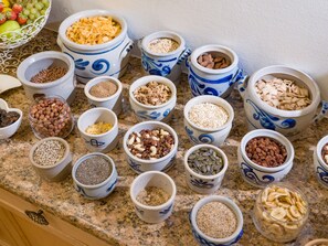 A variety of bowls containing different types of nuts, seeds, and dried fruits on a kitchen counter. - Gartenhotel Rosenhof Kitzbuehel (Oberndorf in Tirol)