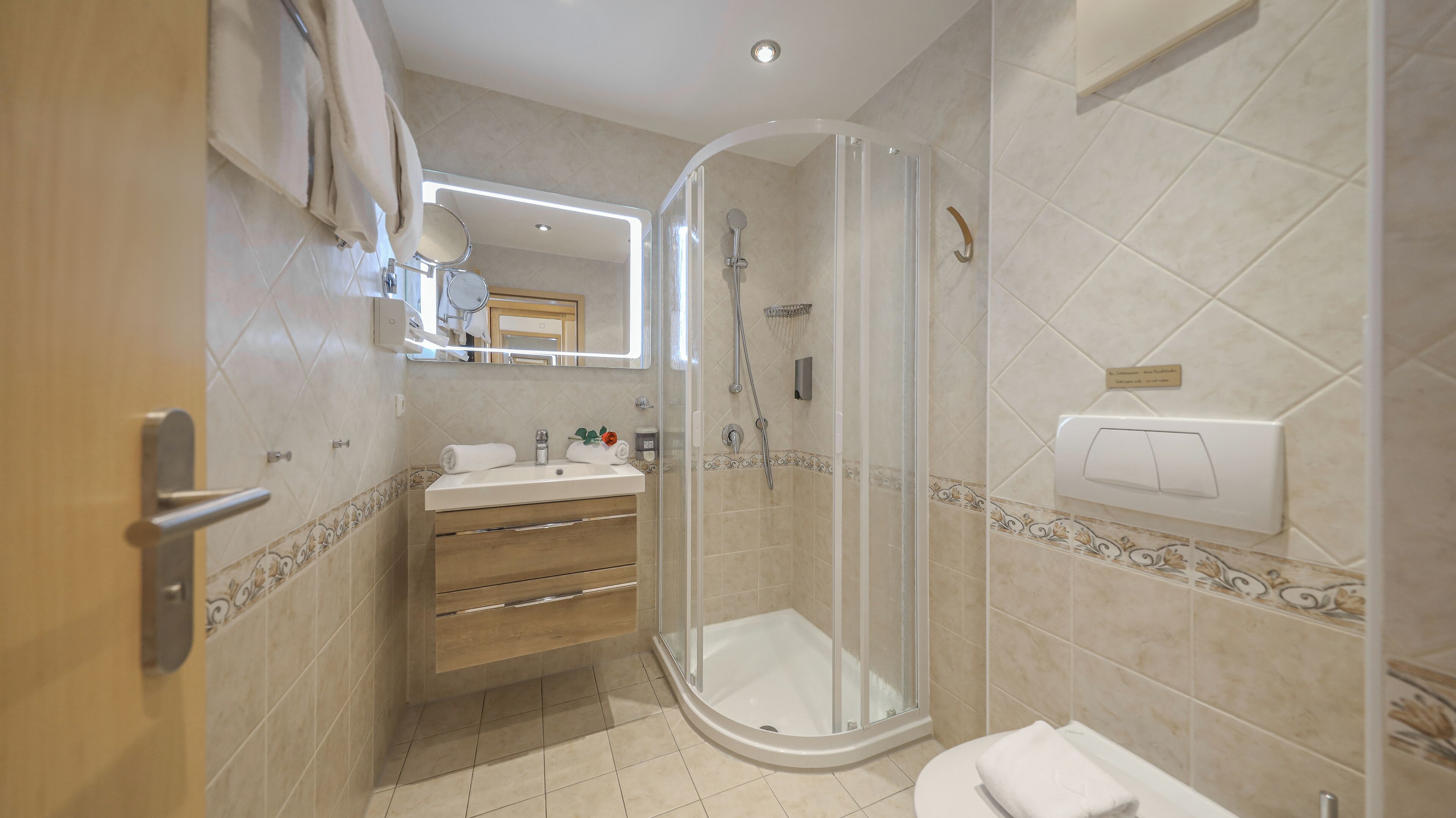Une salle de bain moderne avec une douche à parois de verre, un meuble-lavabo avec un miroir et des toilettes.