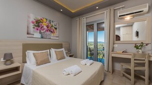 A hotel room with a large bed, a desk, and a balcony with a view. - Katerina (Zakynthos)