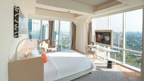 A modern hotel room with a large bed, a desk, a TV, and a city view. - HARRIS Suites FX Sudirman Jakarta (Jakarta)