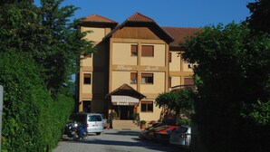 Un edificio con los nombres "Fellergo" y "Russell" en la fachada, un camino de grava, coches estacionados y vegetación circundante.