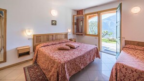 Un dormitorio con una cama grande, una mesita de noche y un ventanal con vistas al exterior.