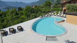 Una piscina con sillas de descanso y vistas a montañas.