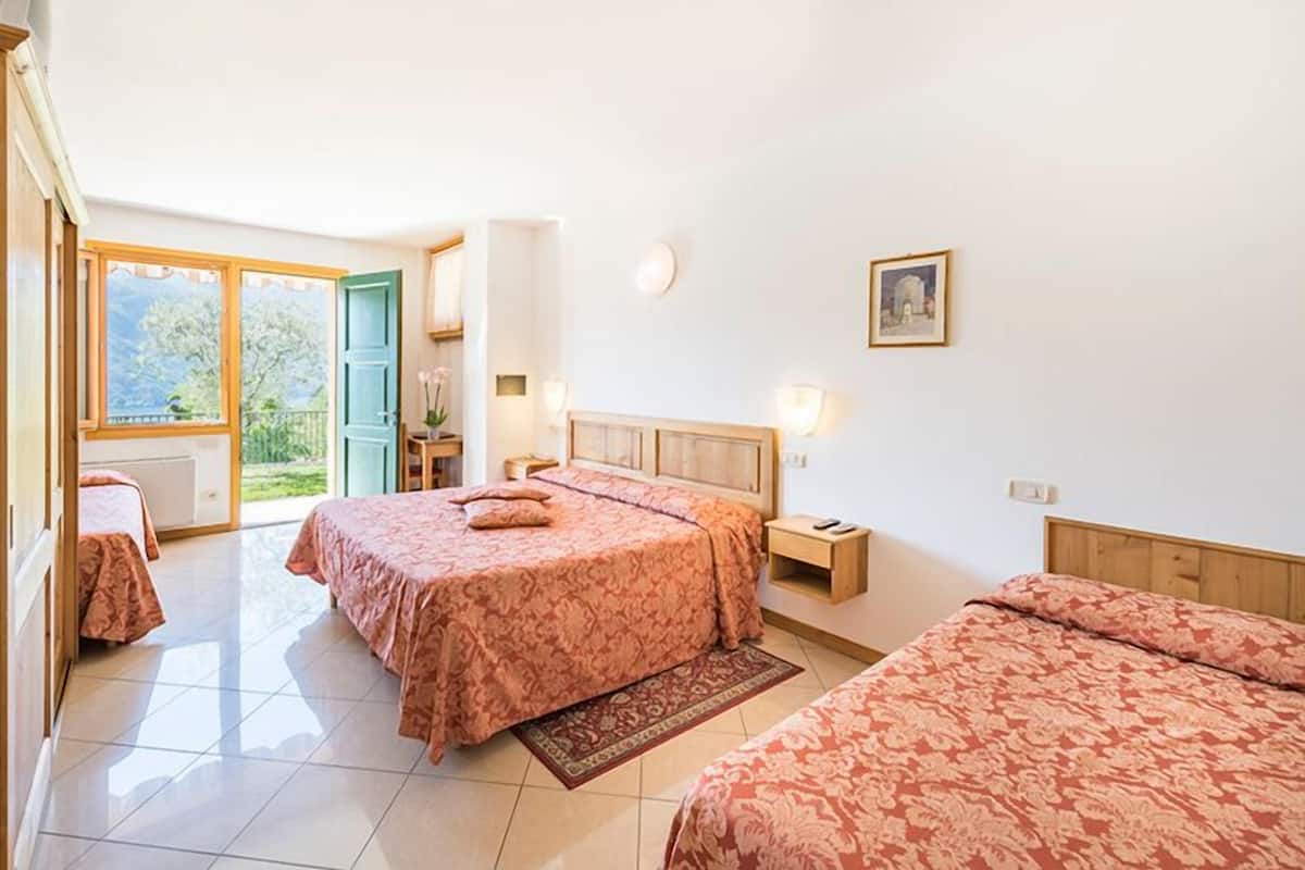 Un dormitorio con dos camas, una ventana y una puerta que da al exterior.