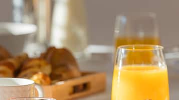 A breakfast setting with croissants, orange juice, and a glass of milk.