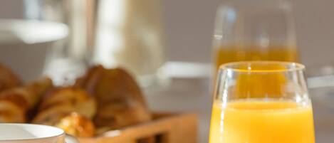 A breakfast setting with croissants, orange juice, and a glass of milk.