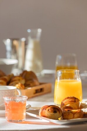A breakfast setting with croissants, orange juice, and a glass of milk. - Hotel Carcarille - Restaurant le C (Gordes)