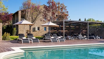 Una piscina al aire libre de temporada, sombrillas