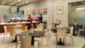 Un interior de restaurante moderno con mostrador, zona de estar y obras de arte en las paredes.
