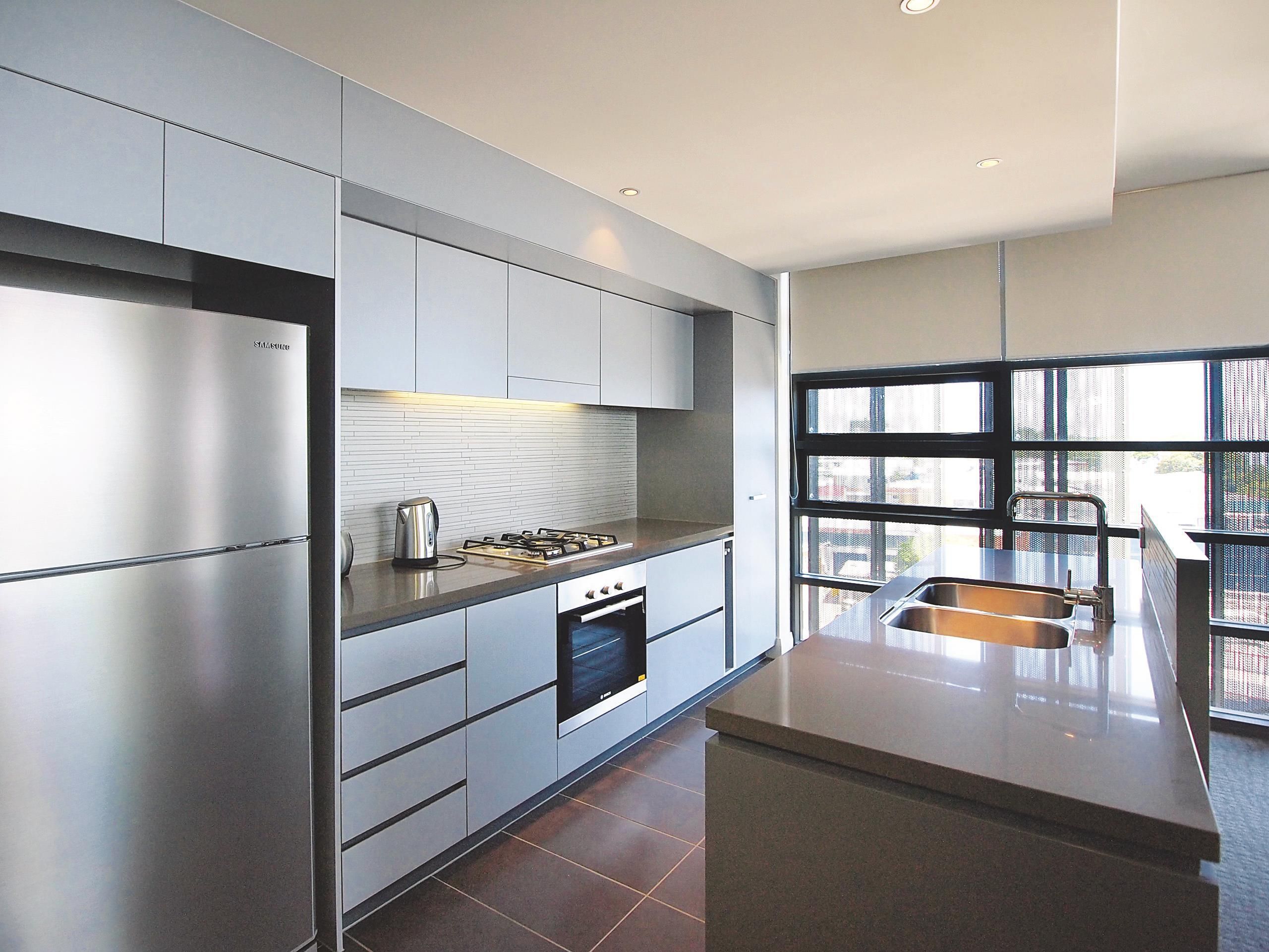 Una cocina moderna con electrodomésticos de acero inoxidable, una estufa a gas y un ventanal con vistas al exterior.