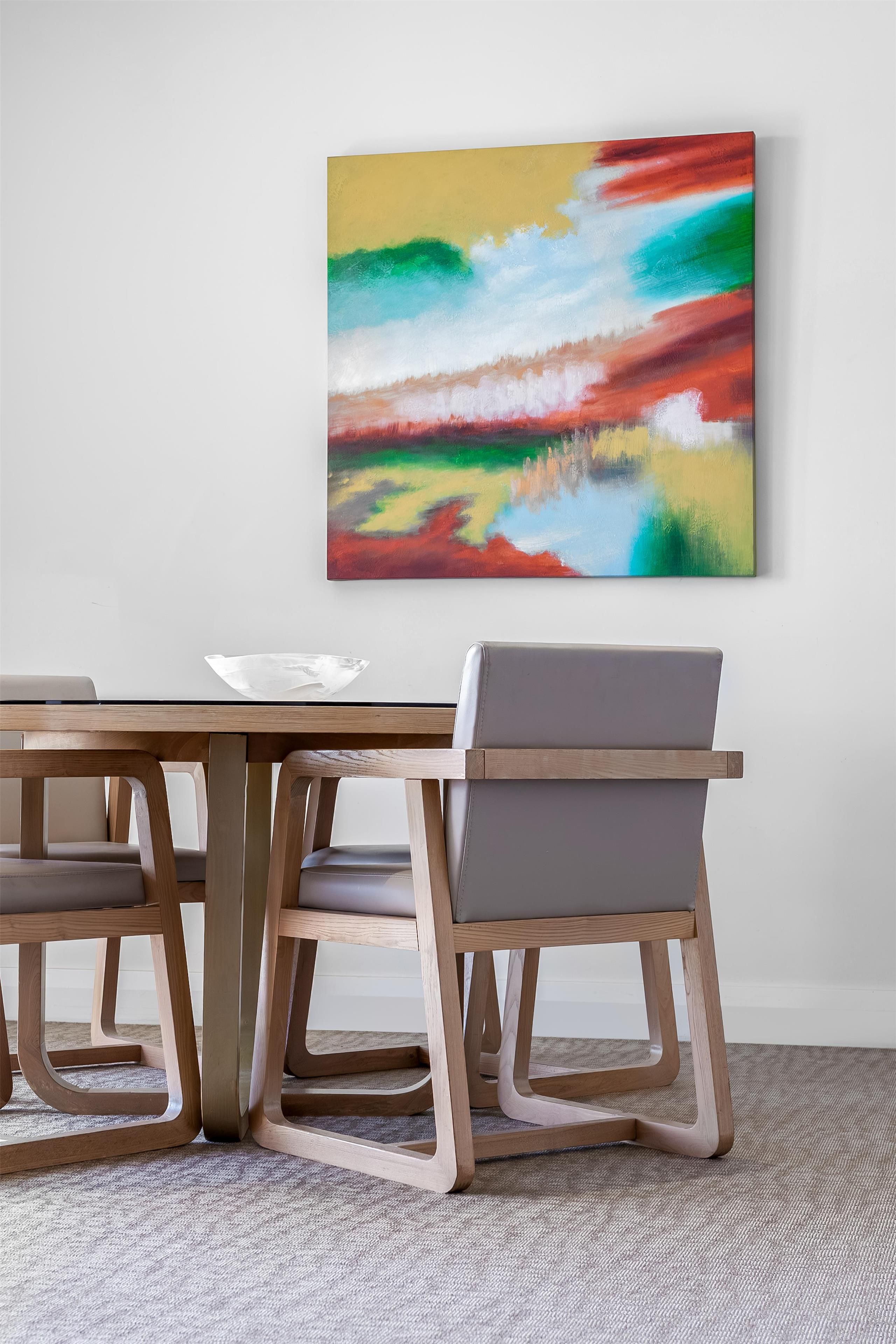 Uma área de refeições com uma mesa e cadeiras de madeira, um quadro abstrato colorido na parede e piso coberto de carpete.