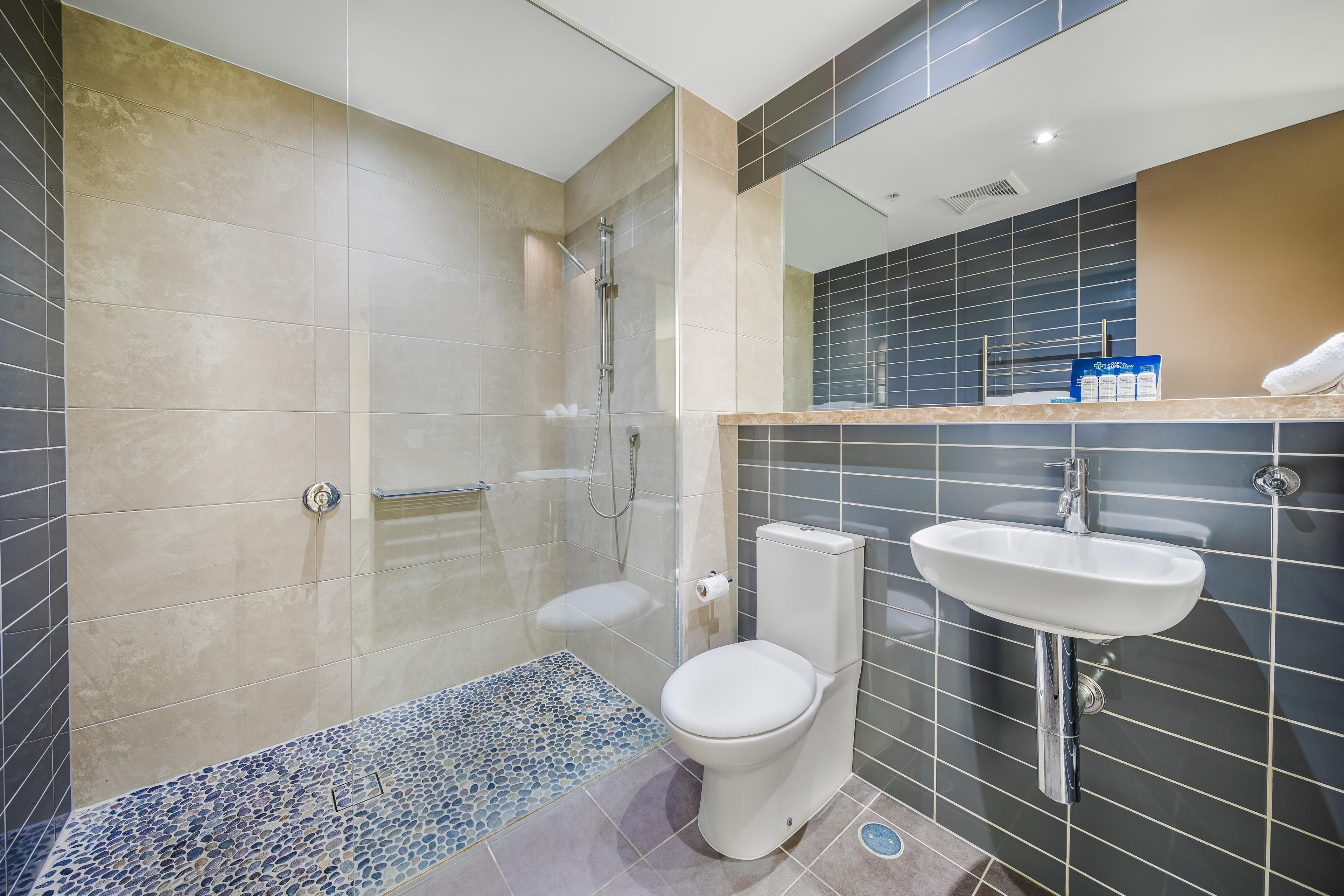 Un baño moderno con ducha, inodoro y lavamanos.