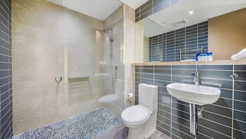 Un baño moderno con ducha, inodoro y lavamanos.