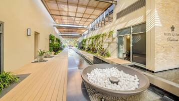 A corridor with a water feature, wooden flooring, and a wall with a sign.