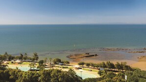 A coastal resort with a swimming pool, beach, and clear views of the sea. - Oaks Redcliffe Mon Komo Suites (Redcliffe)