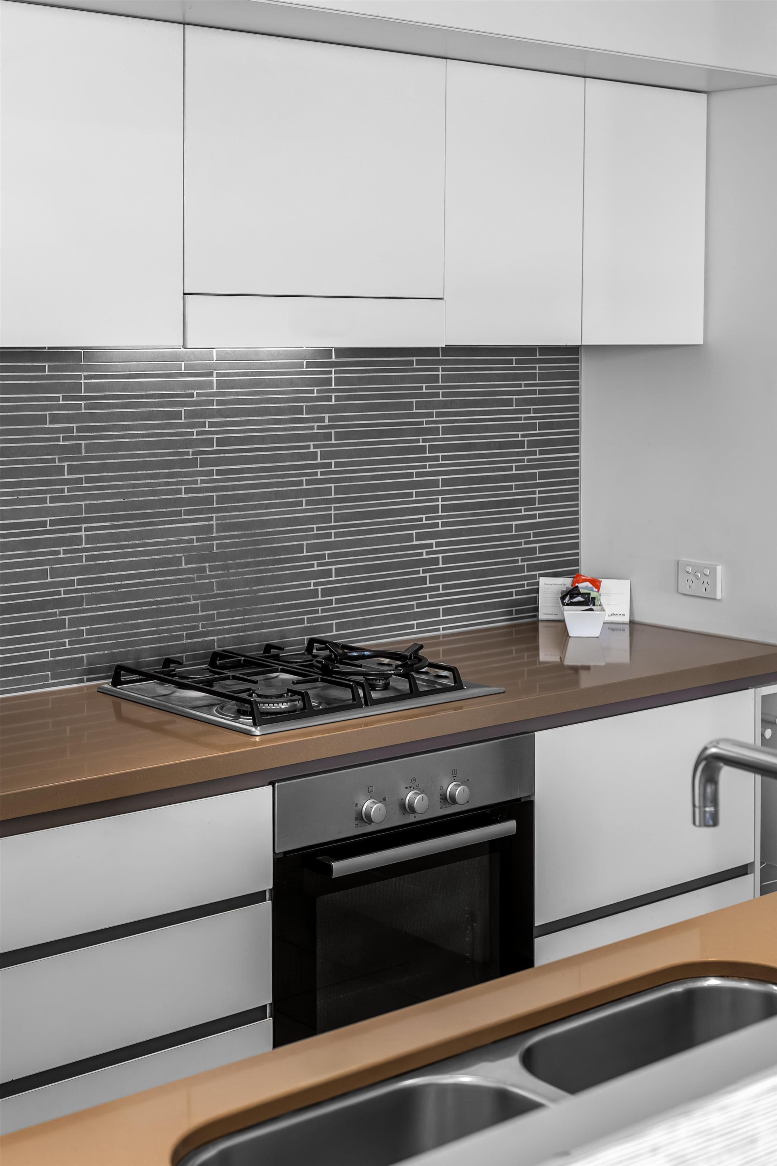 A kitchen with a gas stove, oven, and stainless steel sink.
