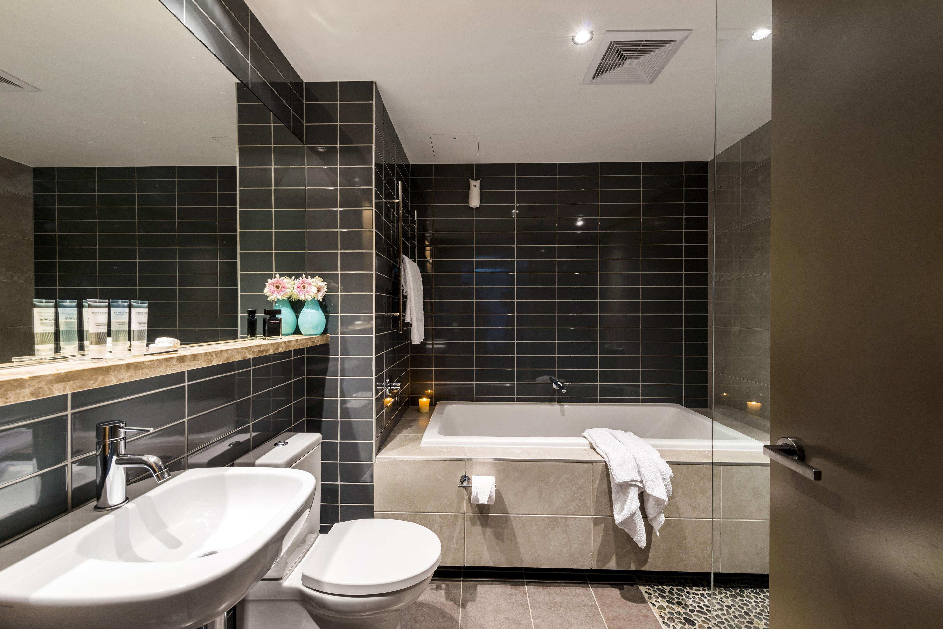A modern bathroom with a bathtub, a sink, and a toilet.