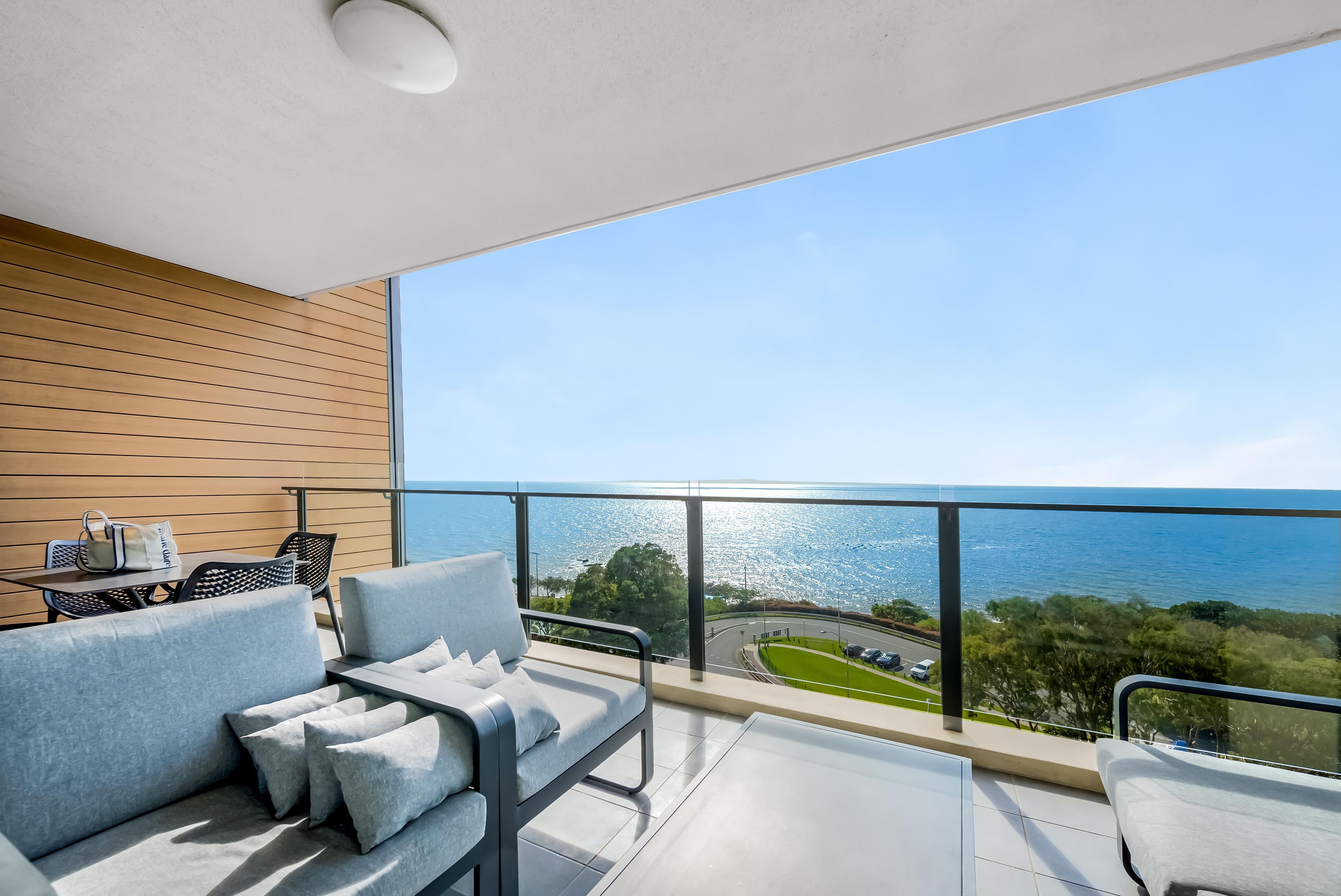 Un balcon avec un canapé et une table, offrant une vue sur la côte.