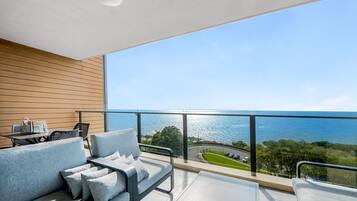 Un balcon avec un canapé et une table, offrant une vue sur la côte.