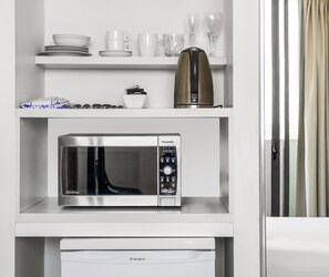A kitchen with a microwave, a coffee maker, and a dishwasher. - Oaks Redcliffe Mon Komo Suites (Redcliffe)