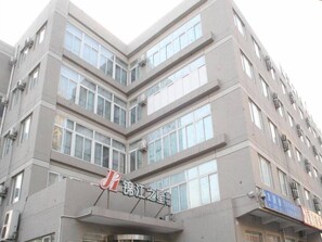 A multi-story building with a prominent sign at the ground level. - Jinjiang Inn Olympic Park (Beijing)
