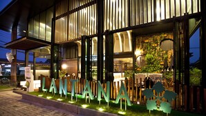 A hotel entrance with illuminated signage and a well-lit facade.