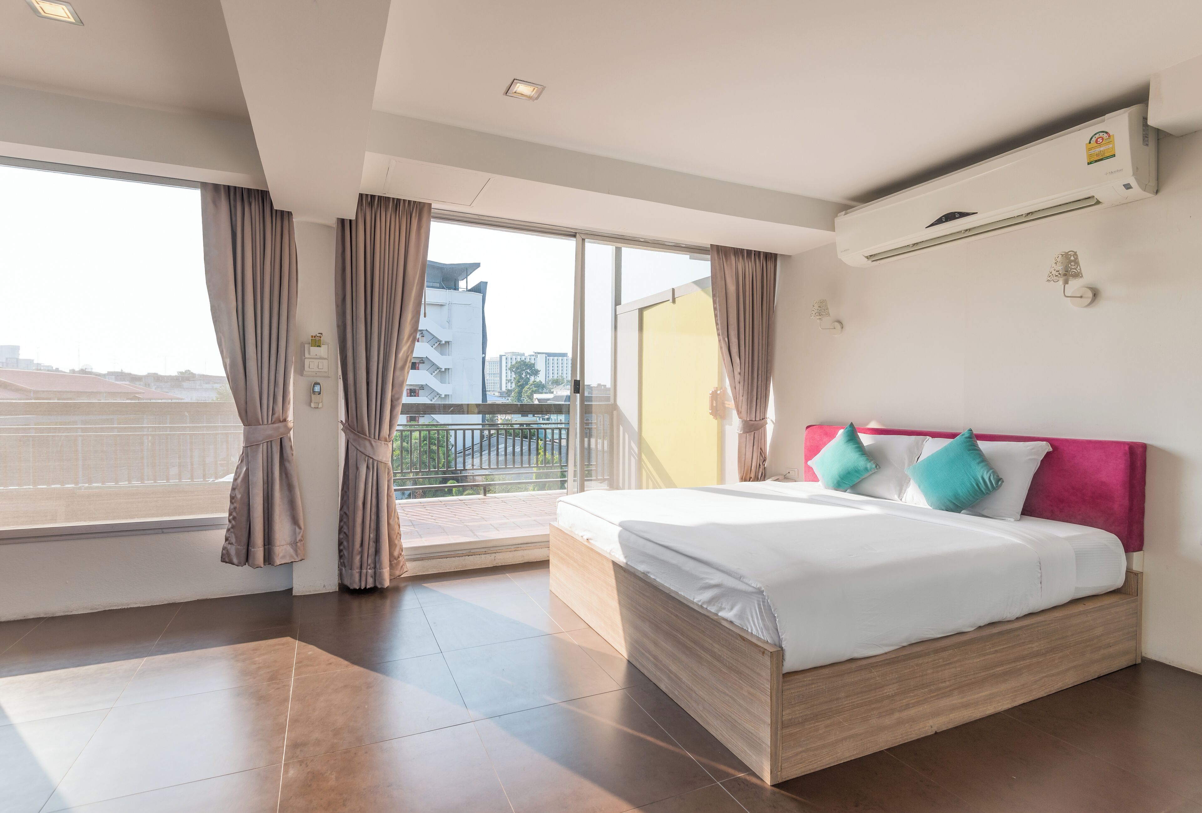 Une chambre d’hôtel moderne avec un grand lit, un balcon et une vue sur la ville.