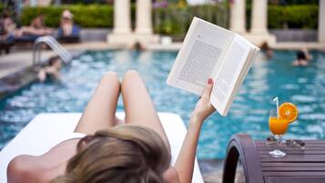Een buitenzwembad, parasols voor strand/zwembad