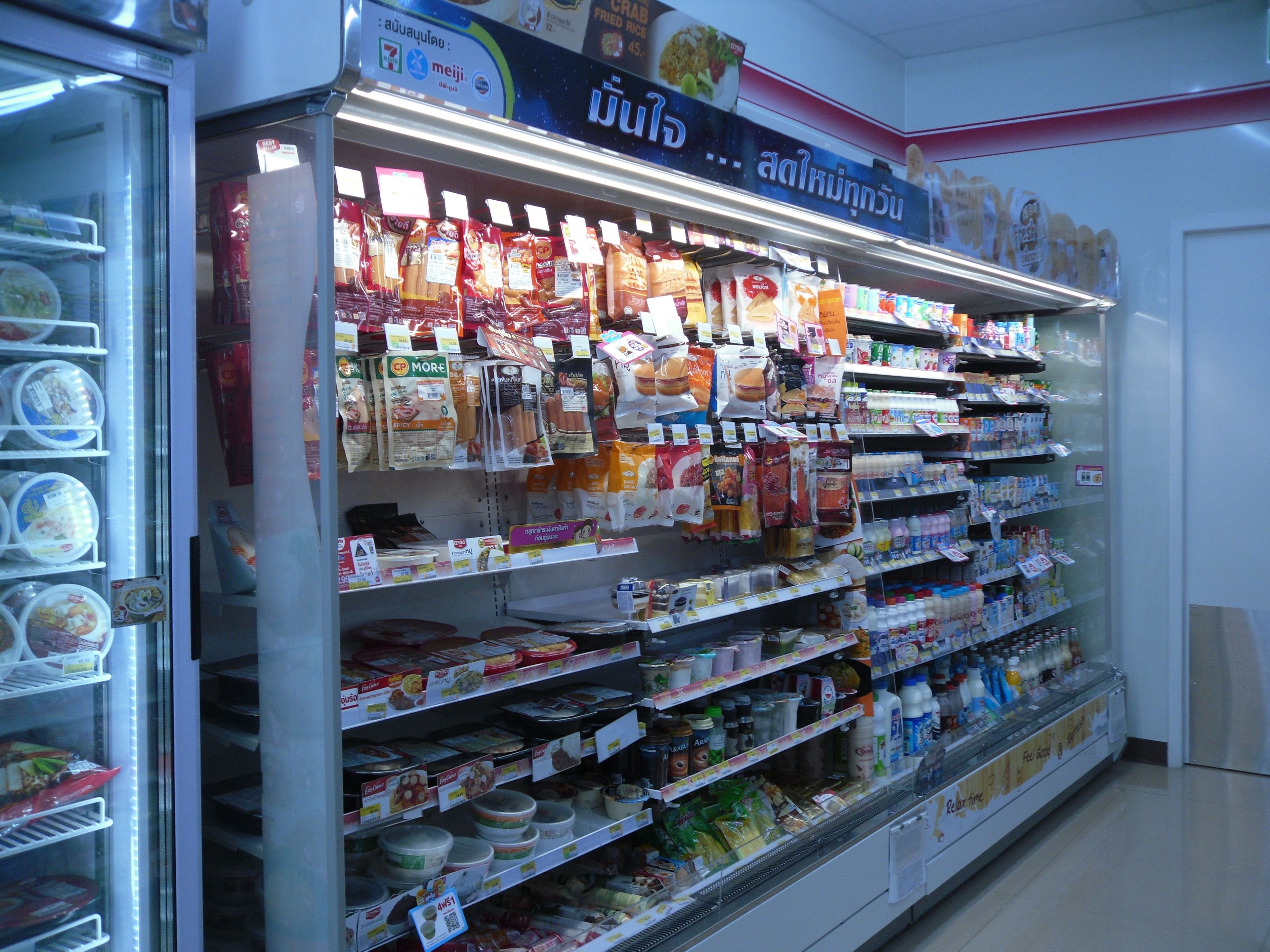 Mostrador refrigerado en una tienda con diferentes productos alimenticios envasados y bebidas.