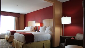 Una habitación de hotel con una cama grande, dos mesitas de noche, un escritorio y una silla.