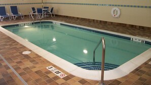 An indoor swimming pool with a tiled floor, a lifeguard stand, and lounge chairs. - Holiday Inn Express Cortland by IHG (Cortland)
