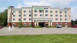 A hotel with a central entrance, multiple floors, and a parking lot. - Holiday Inn Express Cortland by IHG (Cortland)