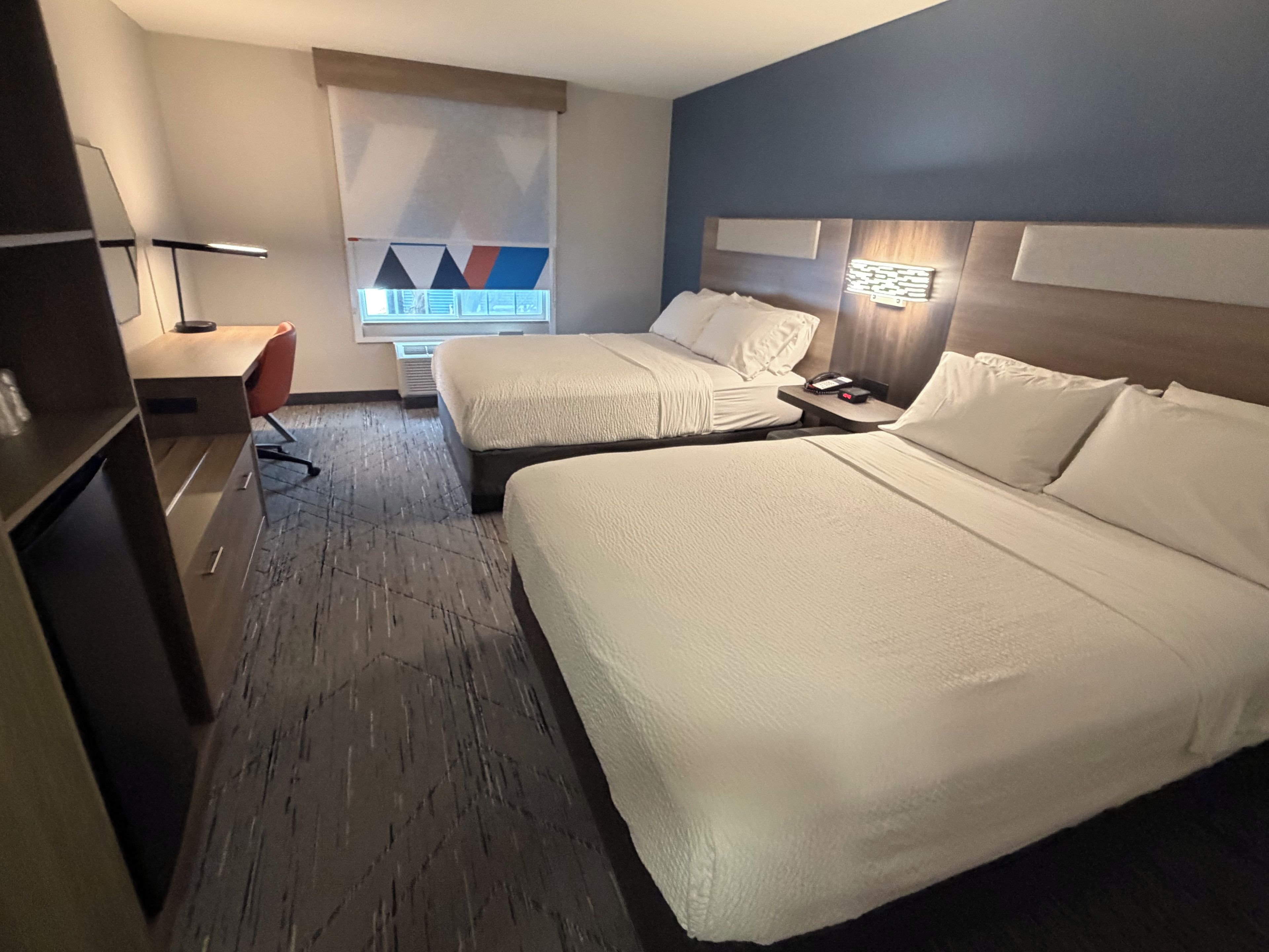 Una habitación de hotel con dos camas, un escritorio y una silla.