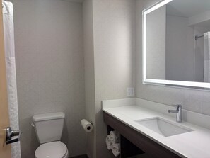 Een moderne badkamer met toilet, wastafel en spiegel.